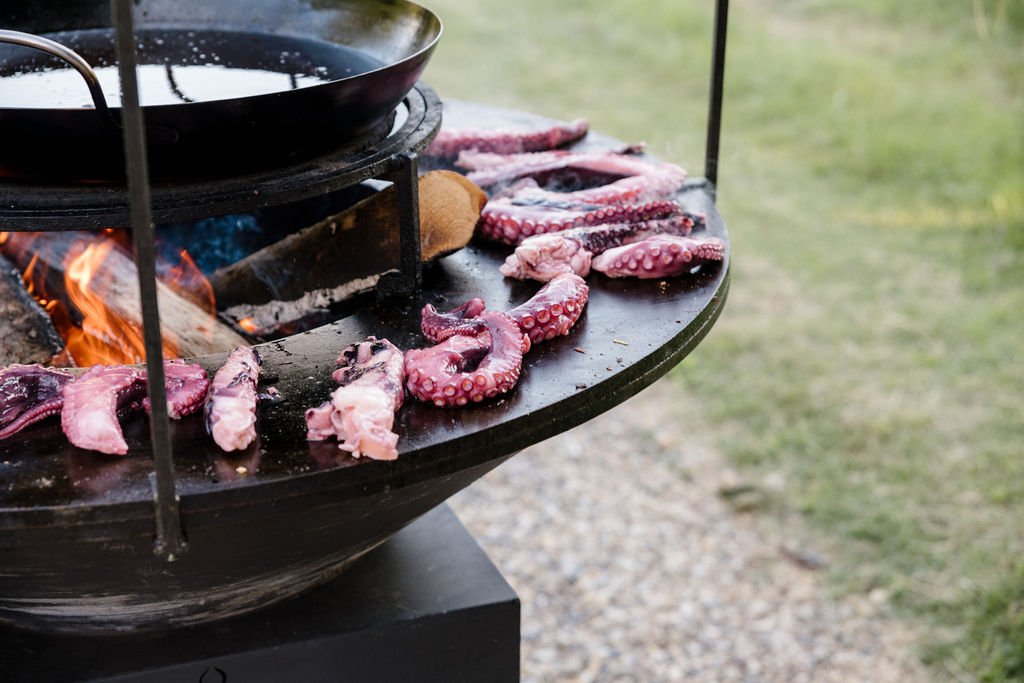 Traiteur mariage grillade de poulpe pour paella cuite au feu de bois, mise en place pour réception en Provence